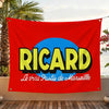 A red flag featuring the name RICARD in yellow text inside a blue circle with French text below.