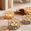 A close-up of a silver crystal lantern holder with warm yellow light illuminating small crystals.