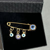 Elegant gold and silver evil eye brooch pin featuring blue and white glass eyes.