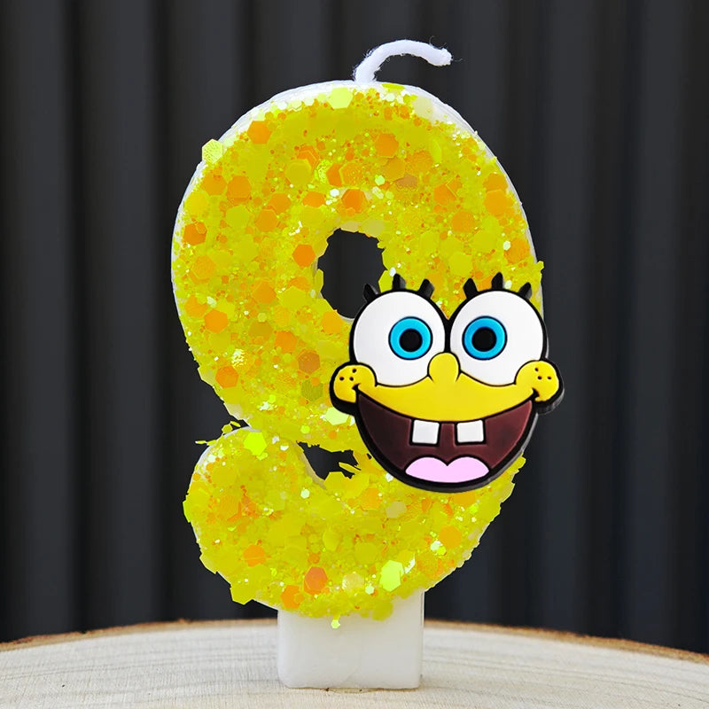 A yellow sponge cake candle shaped like the number 0, featuring a cartoon face.