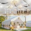 Elegant white draped fabric backdrop for an outdoor event featuring chandeliers and floral arrangements.
