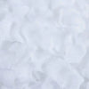 White artificial rose petals scattered on a surface for wedding decoration.