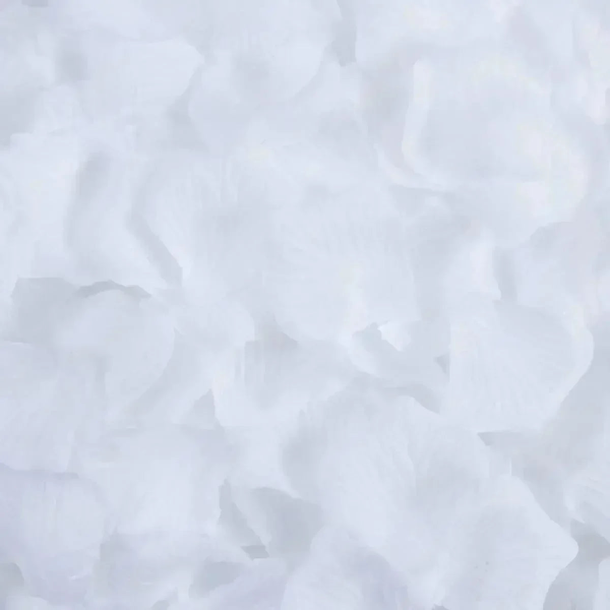 White artificial rose petals scattered on a surface for wedding decoration.