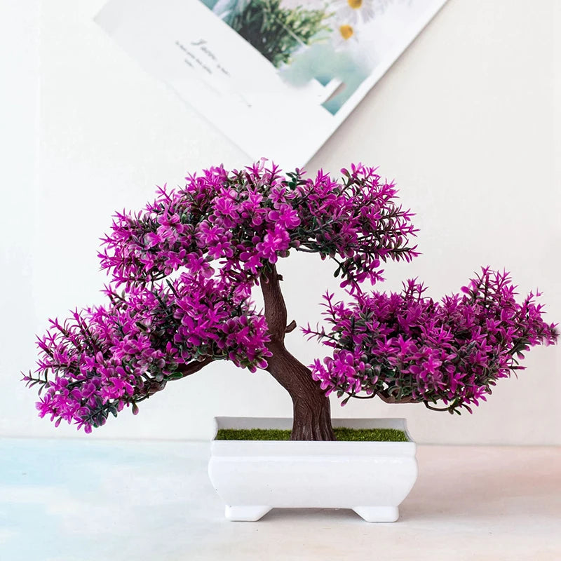 Un arbre bonsaï artificiel réaliste avec un feuillage magenta vibrant, présenté dans un pot blanc.