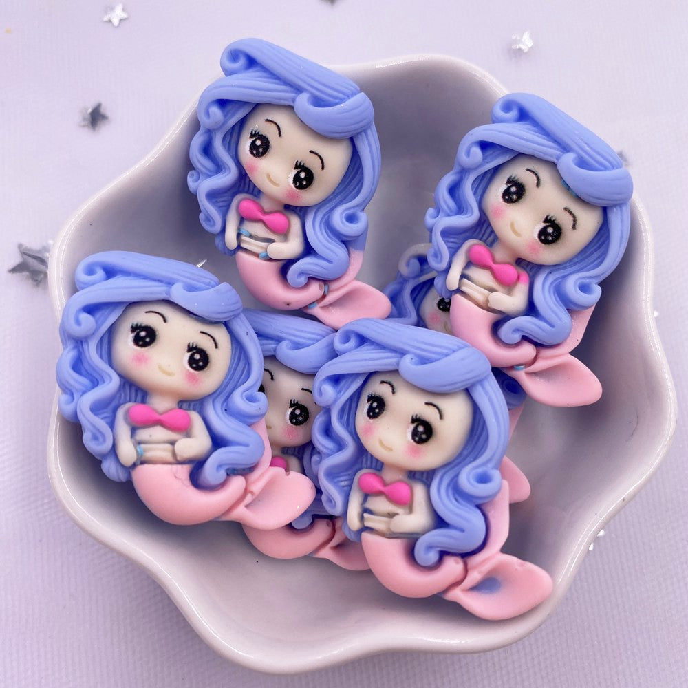 A set of four cute resin figurines depicting mermaid princesses with blue and pink hair and clothing.