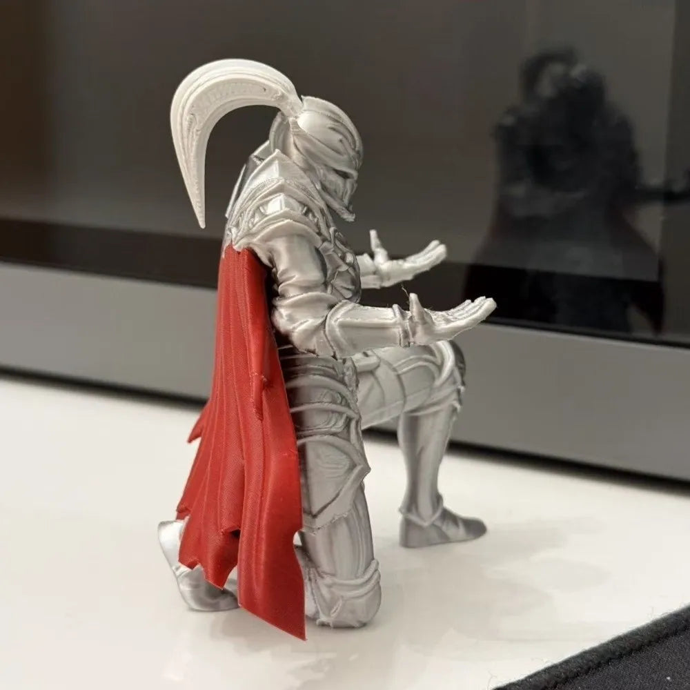 A silver 3D printed knight figurine with a red cape, used as a unique desk organizer.