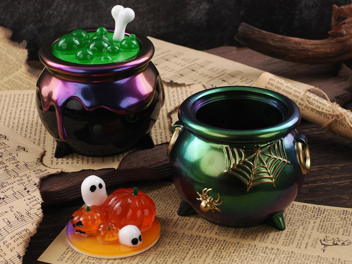 A set of Halloween silicone molds, including a green candle mold and an orange pumpkin mold, displayed on parchment paper.