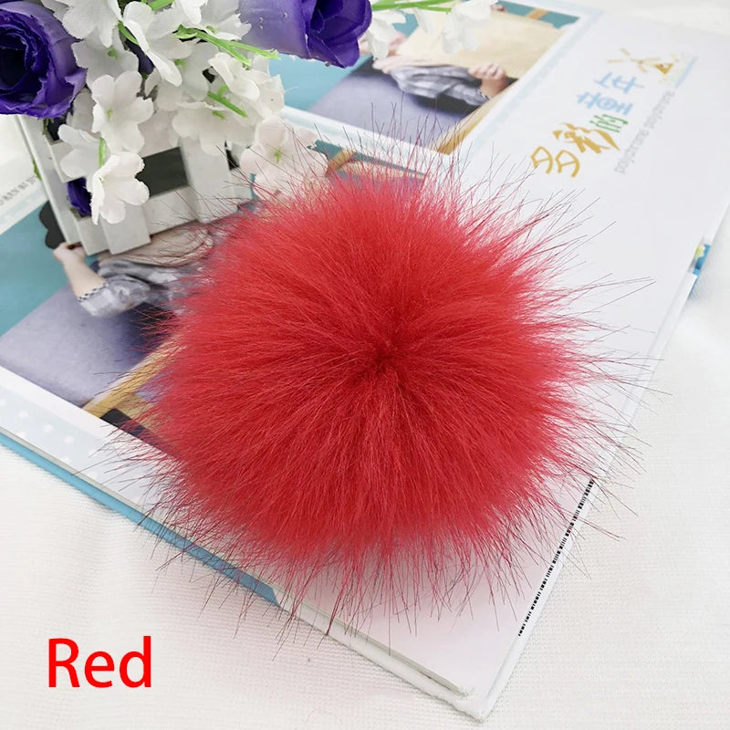 Pompon accessoire en fausse fourrure rouge vif sur un livre ouvert.