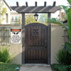 A dark wooden door with a decorative iron sign above it, set within a porch structure.