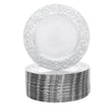 A stack of silver embossed charger plates with decorative rims.