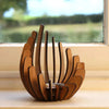 A wooden lotus candle holder decoration with curved slats resting on a windowsill.