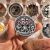 A hand holds a silver-plated commemorative coin featuring a knight and a brother motif.