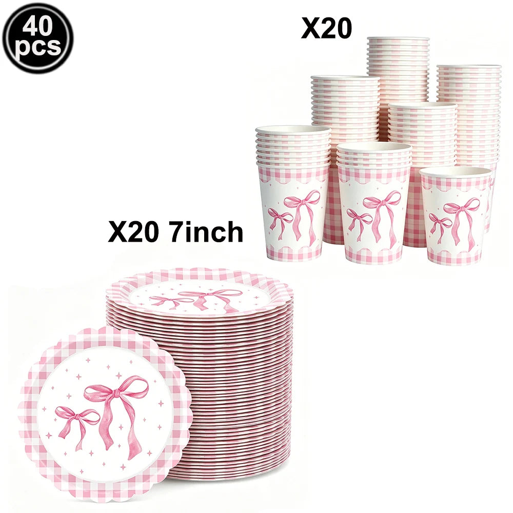 A set of pink and white striped cups and plates with pink bows for a birthday party theme