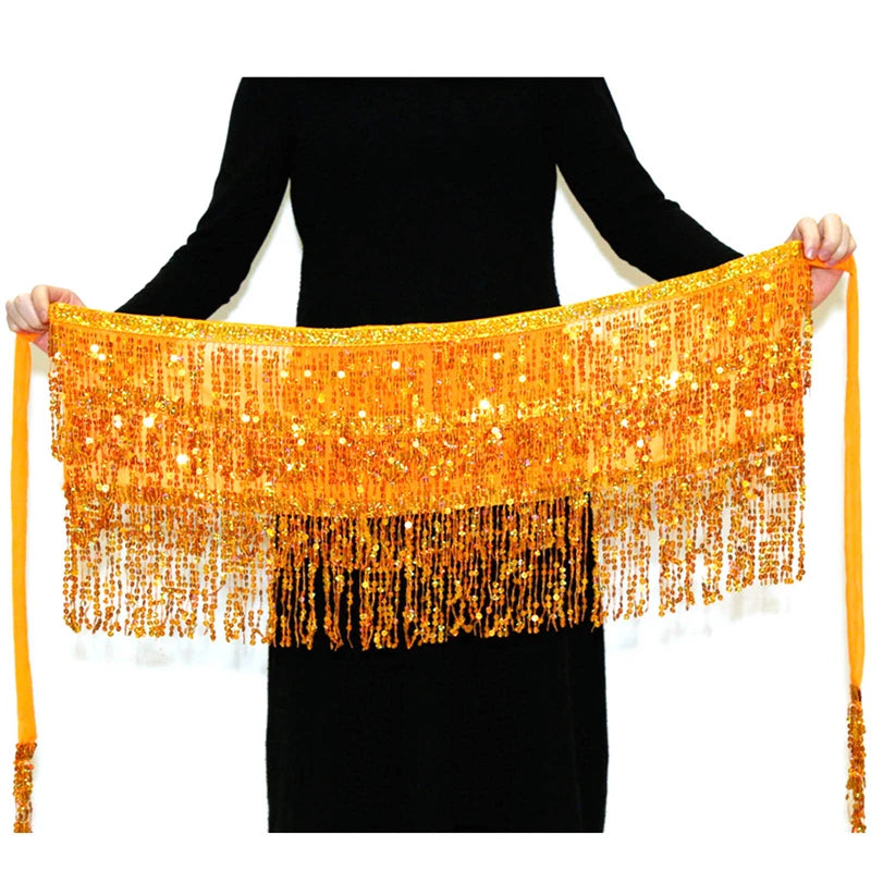 Orange sequin hula dancer skirt with long fringe and tassel belts displayed against a black background
