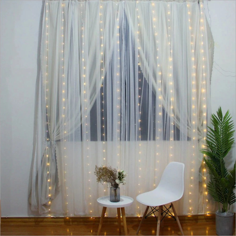 White sheer curtains decorated with warm fairy lights illuminating a window area.