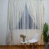 White sheer curtains decorated with warm fairy lights illuminating a window area.