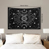 A black tapestry wall hanging featuring a psychedelic sun and moon mandala design on a dark background.