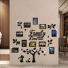 A wall collage featuring a family tree design with various framed photos and leaves on a light beige wall.