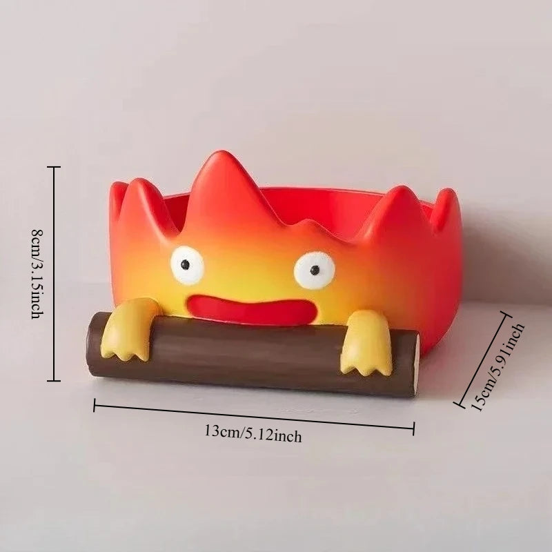A resin cartoon fire person tray with an orange and red face molded onto a brown wooden base.