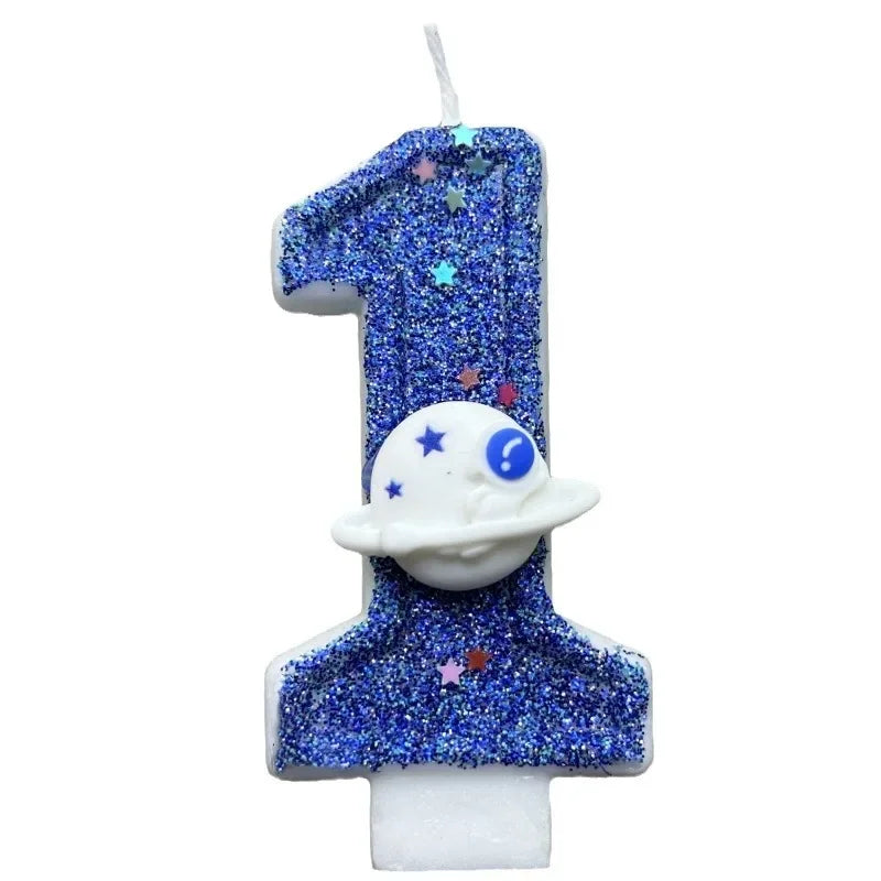 A birthday candle shaped like the number 1, covered in blue glitter and featuring a white planet design.