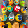 A collection of colorful rubber duck bath toys in various shades and designs.