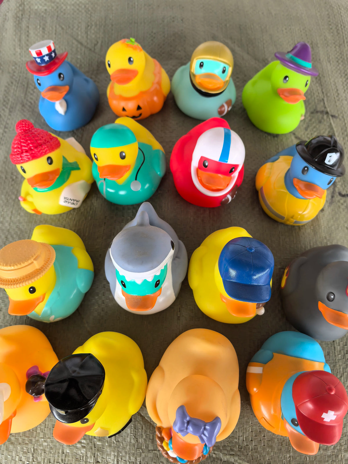 A collection of colorful rubber duck bath toys in various shades and designs.