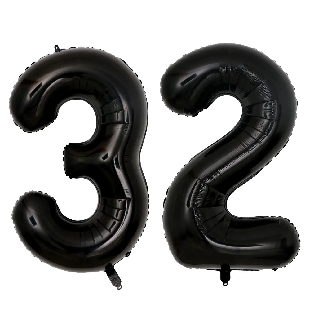 A set of two giant black foil balloons shaped like the numbers 3 and 2.