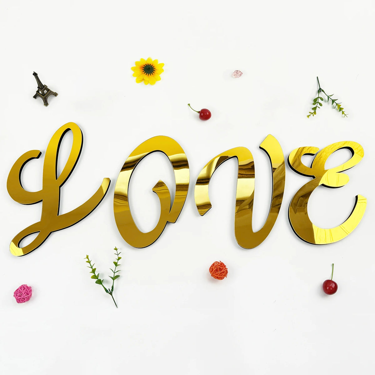 Gold 3D acrylic letter wall stickers spelling LOVE with scattered yellow flowers and red berries