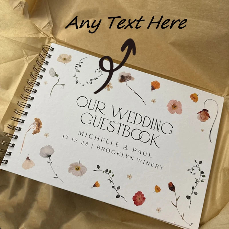 A white spiral-bound guestbook with floral illustrations and the text Our Wedding Guestbook for Michelle & Paul.