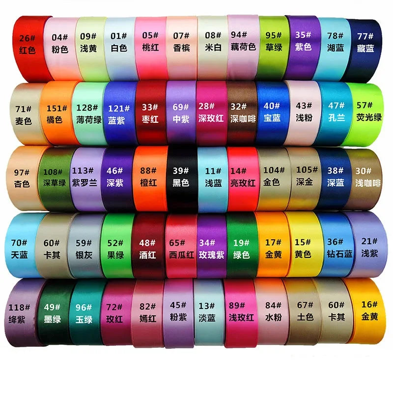 A collection of satin ribbon rolls in various colors and patterns, arranged in a row.
