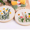 Punch needle embroidery kit featuring floral designs on stamped cloth with yarn tools