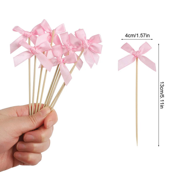 Pink bow cupcake toppers on wooden sticks with dimensions 4cm long and 13cm total length.