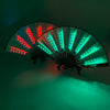 A multi-mode LED party fan with green and red lights is shown open against a dark background.