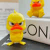 A yellow 3D printed angry duck figurine with orange beak sitting on a dark surface.