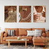 Ein Set aus drei Leinwanddrucken mit eleganten Gold- und Bronz-Nagelkunst-Designs, präsentiert über einem braunen Ledersofa.