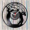 A black wall clock face featuring silhouettes of musicians playing instruments against a background of vinyl records.