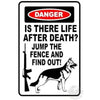 A vintage tin sign with a black and white graphic featuring the text Is there life after death? Jump the fence and find out!