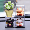 A set of solar-powered waving lucky cat figurines in various colors and sizes displayed on a dark surface.