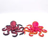 A pair of articulated 3D printed octopus figurines, one pink and one orange, displayed against a white background.
