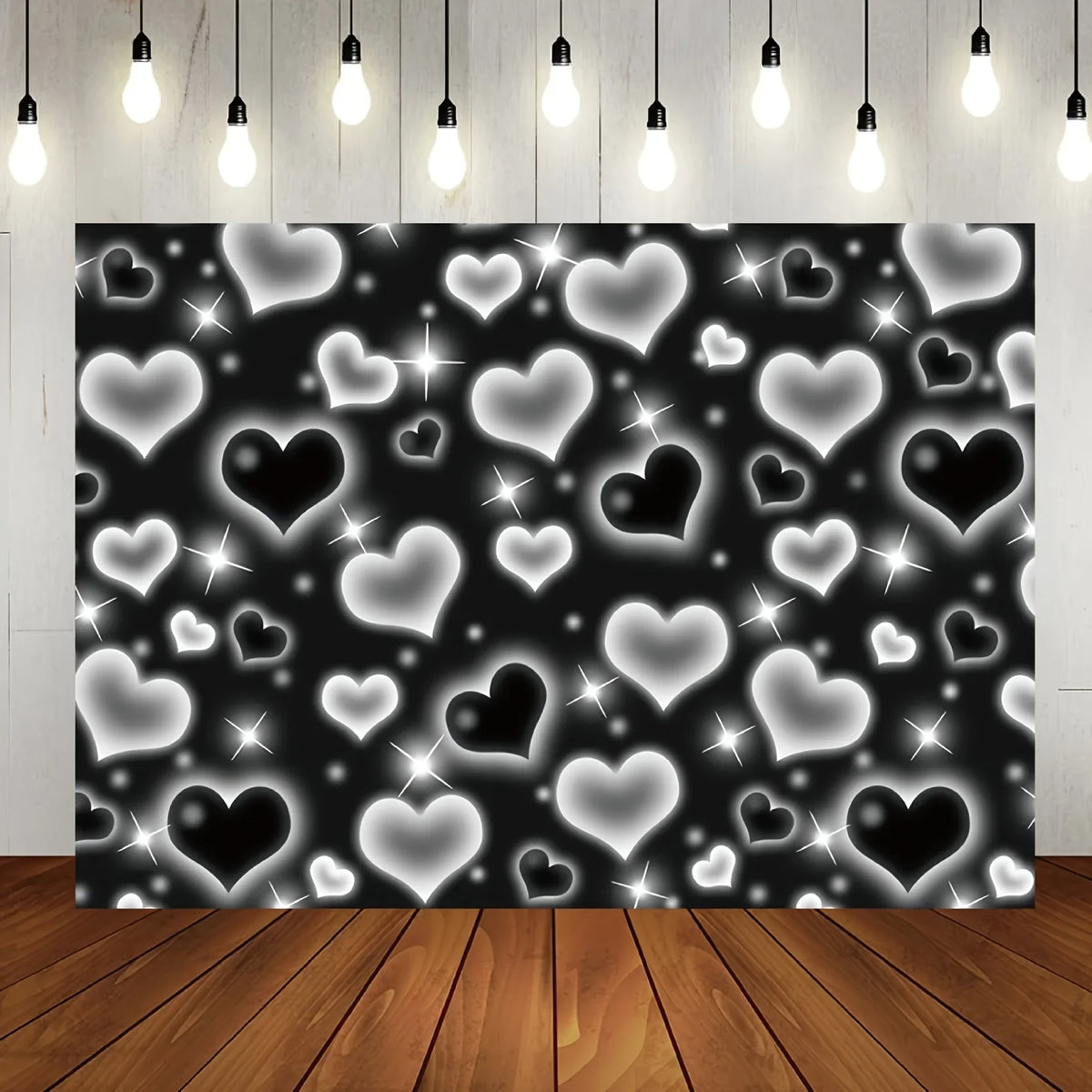 A dark background covered with numerous glowing white and black heart shapes sparkling like glitter for a photo backdrop.