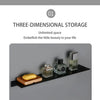 A modern matte black wall shelf displaying various small glass and wooden containers.