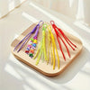 A collection of colorful nylon ropes in purple, green, yellow, and red are displayed on a wooden board.