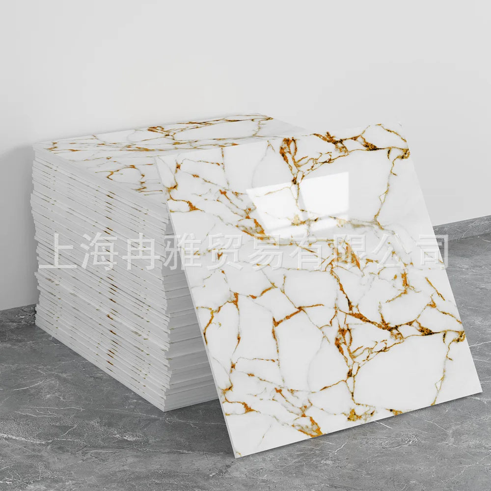 Stack of white marble peel-and-stick tiles featuring brown veining on a gray background.