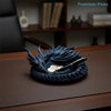 A dark blue dragon design decorative tray for jewelry and small items resting on a wooden surface.