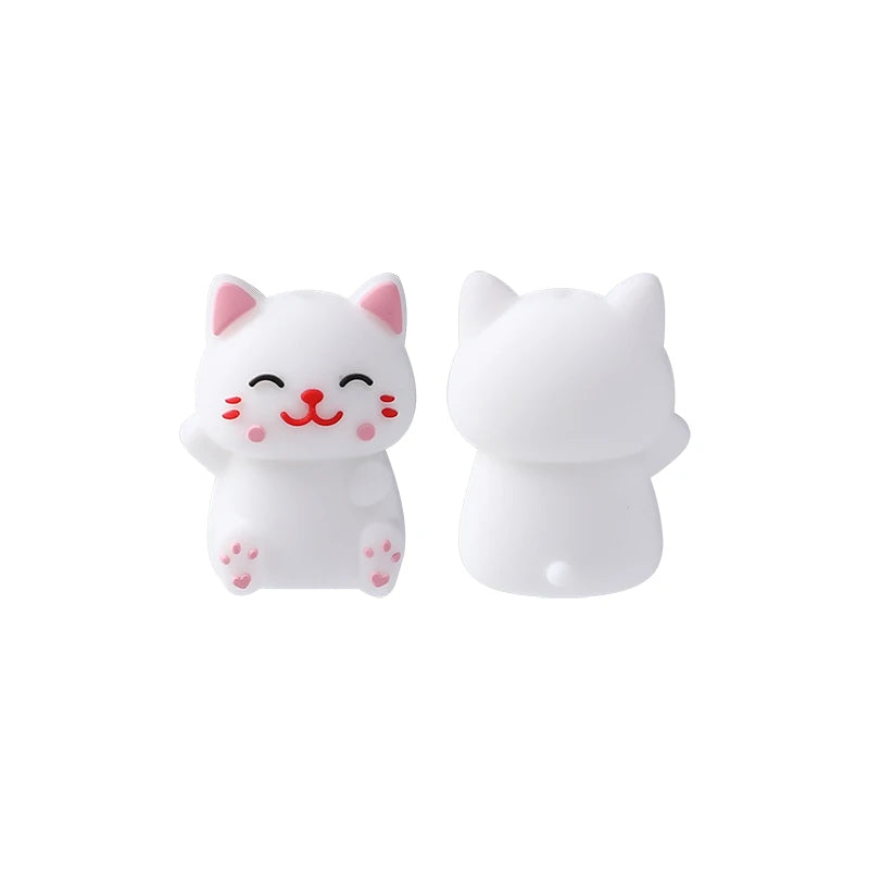 A pair of white silicone cat figurines with pink accents for jewelry making and DIY crafts