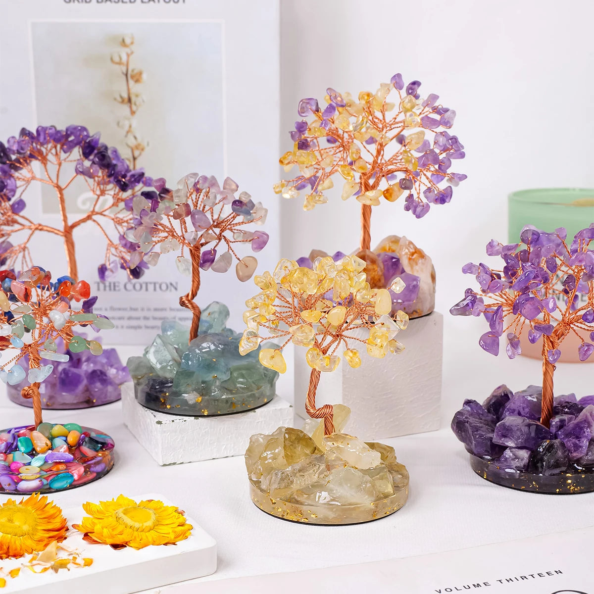 A collection of natural crystal trees featuring purple, yellow, and orange crystals used for home decor.