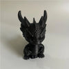 Figurine de dragon miniature noir pour bureau avec des cornes pointues et des écailles texturées.