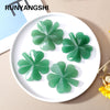 Green natural aventurine quartz four-leaf clover crystal statue on a white plate