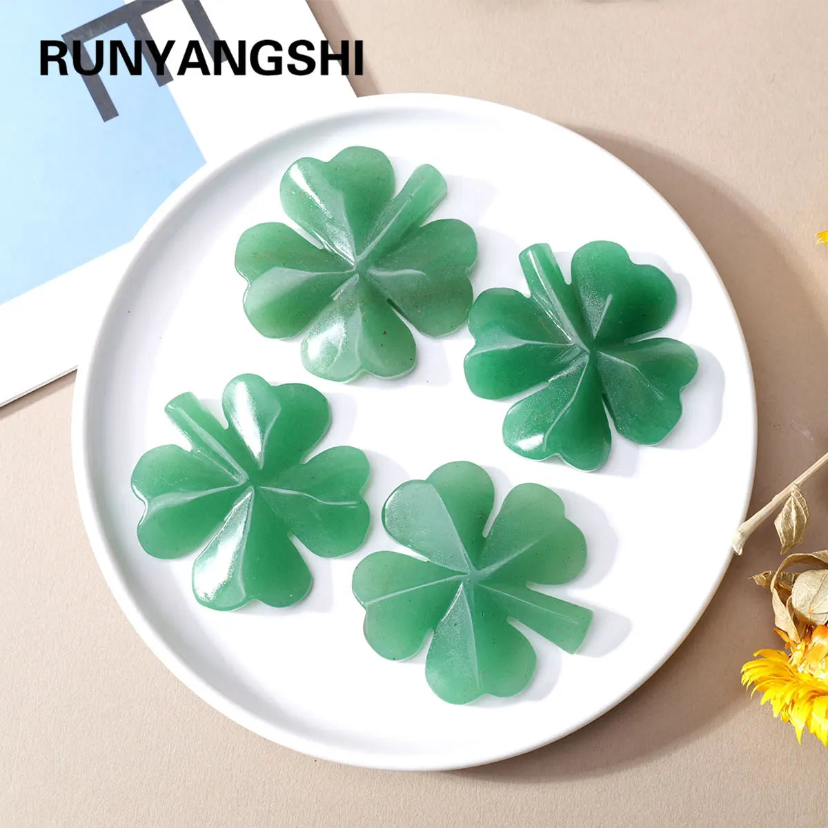 Green natural aventurine quartz four-leaf clover crystal statue on a white plate