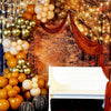 A decorative arch made of round latex balloons in gold, bronze, and cream colors against a rustic background.